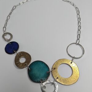 Etched brass, enamelled copper, and eco silver circles linked together forming a constellation. with a paperclip style silver chain.