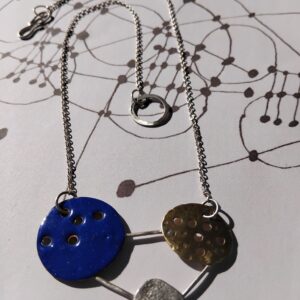 Mixed material necklace made from a Blue Enamelled Copper Circle, Hammered Brass Circle, and textured silver circle linked together to make and abstract constellation motif. hung on a silver chain. With Handmade S Hook Clasp.