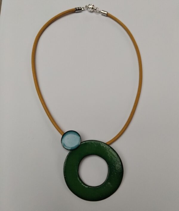 Green enamelled circle with sky blue circle detail hung on a yellow leather cord