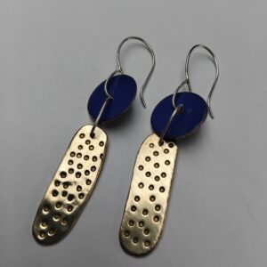 Royal blue enamelled circle with hammered brass irregular oval shape with hammered dot details. Hung from silver ear hooks