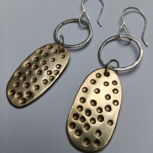 Hammered eco silver circle with irregular hammered dotty brass shape. Hung on and eco silver ear hook