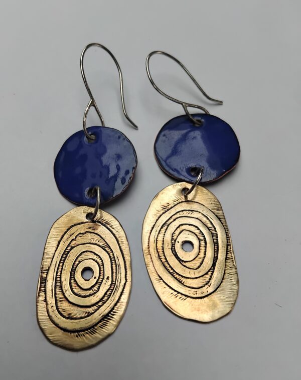 Royal blue enamelled copper circles with etched circles on irregular oval brass shapes. Hung on eco silver ear hooks