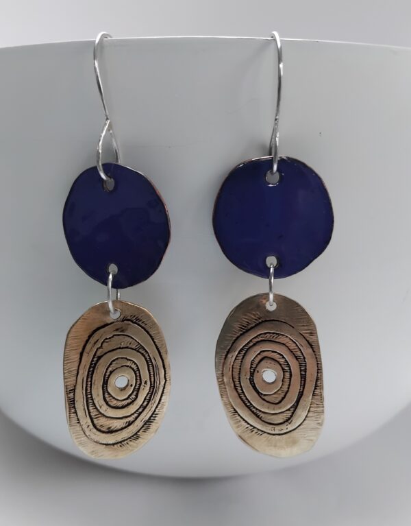 Royal blue enamelled copper circles with etched circles on irregular oval brass shapes. Hung on eco silver ear hooks